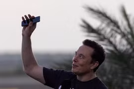 Elon Musk giơ điện thoại lên trời trong cuộc họp báo chung với CEO của T-Mobile, Mike Sievert tại trạm không gian SpaceX Starbase, ở Brownsville, Texas, Mỹ, ngày 25/8/2022. Ảnh: Reuters.