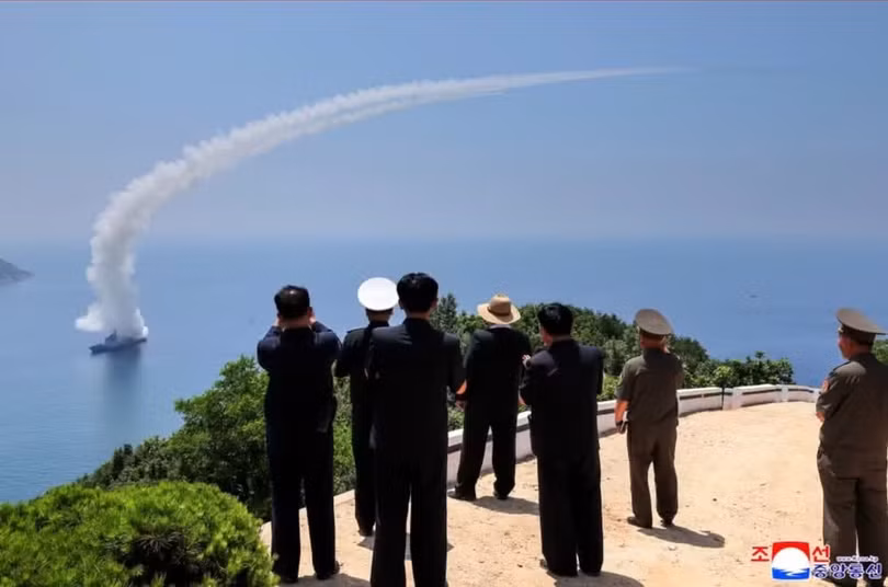 Nhà lãnh đạo Kim Jong-un và các quan chức chứng kiến khu trục hạm Kang Kun phóng thử tên lửa. Ảnh: KCNA/Reuters.