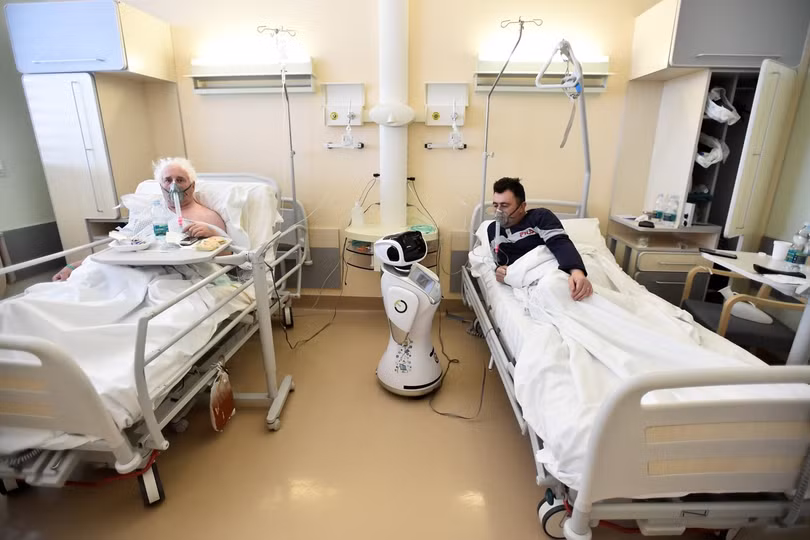 Một y tá robot đang chăm sóc người bệnh trong phòng bệnh (Ảnh: Reuters). Một y tá robot đang chăm sóc người bệnh trong phòng bệnh (Ảnh: Reuters).