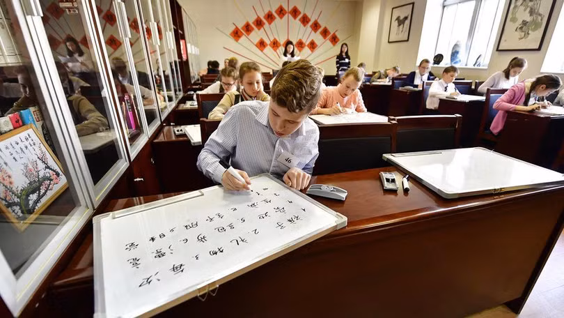 Học sinh Mỹ học viết chữ Hán trong lớp học Khổng Tử (Ảnh Getty).