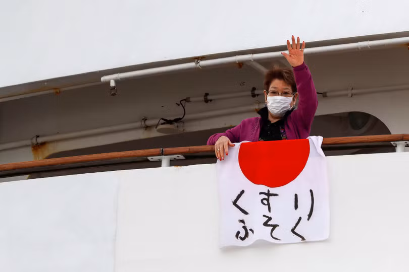 Một hành khách với lá cờ Nhật trên viết các chữ "không có thuốc chữa bệnh" (Ảnh: Reuters) Một hành khách với lá cờ Nhật trên viết các chữ "không có thuốc chữa bệnh" (Ảnh: Reuters)