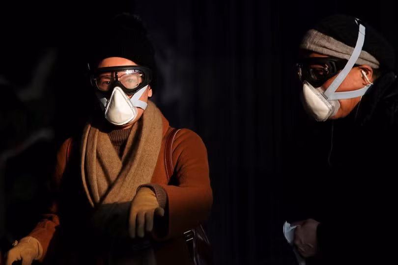 Hai hành khách đeo kính phòng hộ lao động và mặt nạ. (Ảnh: Reuters) Hai hành khách đeo kính phòng hộ lao động và mặt nạ. (Ảnh: Reuters)