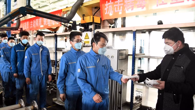 Công nhân một nhà máy nhận khẩu trang phòng hộ trước khi vào nhà máy sản xuất (Ảnh: Tân Hoa xã) Công nhân một nhà máy nhận khẩu trang phòng hộ trước khi vào nhà máy sản xuất (Ảnh: Tân Hoa xã)