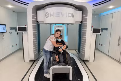 Bé Stephen De La Torre, 7 tuổi, là người đầu tiên được xạ trị bằng “siêu máy” xạ trị Proton tại Mỹ. Ảnh: Phong Lan.