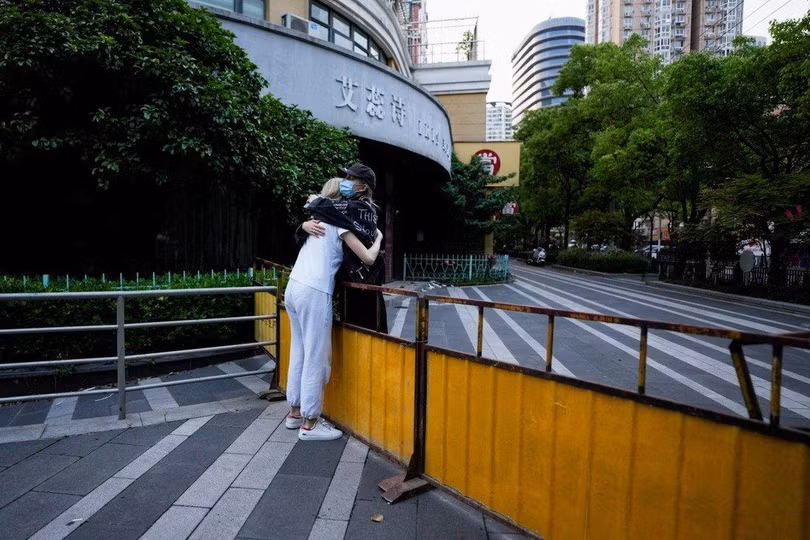Hai cô gái đứng ôm nhau qua hàng rào, giữa lúc phong tỏa tại thành phố Thượng Hải, ngày 16/5 (Ảnh: SCMP)
