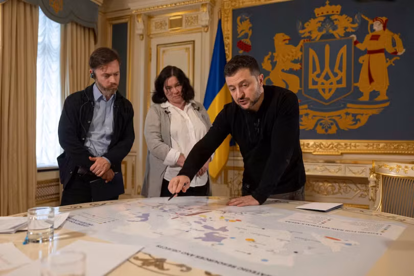 Tổng thống Ukraine Volodymyr Zelensky cho các nhà báo xem bản đồ các nguồn lực và khoáng sản chiến lược trong cuộc phỏng vấn ngày 7/2. Ảnh: Reuters.