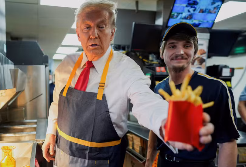 Ông Donald Trump phục vụ khoai tây chiên trong một nhà hàng đồ ăn nhanh ở Pennsylvania (Ảnh: Reuters)