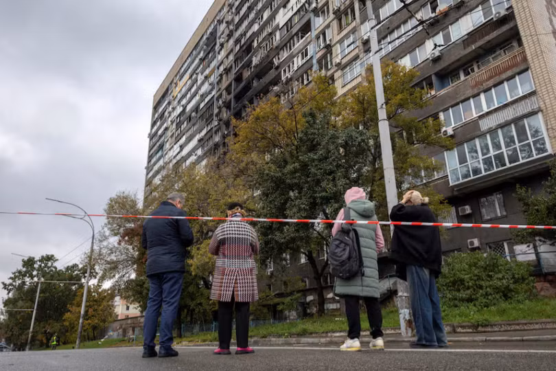 Người dân ở thủ đô Kiev, Ukraine đứng trước một tòa nhà bị hư hại trong sáng 10/10. Ảnh: Reuters.