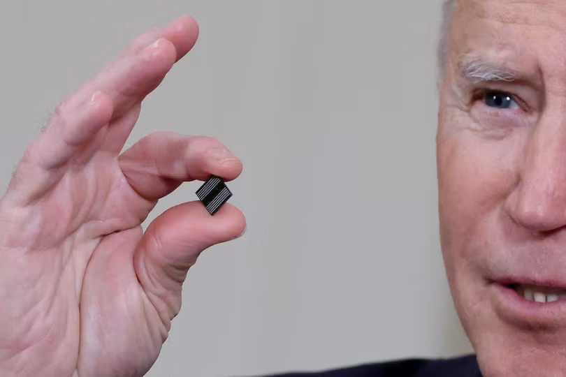 Tổng thống Mỹ Joe Biden cầm trên tay một microchip trong lúc phát biểu, trước khi ký một sắc lệnh giải quyết vấn đề thiếu hụt chip toàn cầu trong tháng 2/2022 (Ảnh: Reuters)