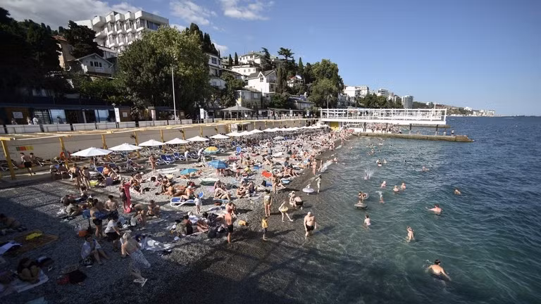 Người dân ở bãi biển Massandra tại thị trấn nghỉ mát Yalta bên bờ Biển Đen ở Crimea. Ảnh: Sputnik.