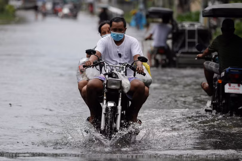 Một người đàn ông lái xe máy trong lúc bão Molave đổ bộ vào tỉnh Pampanga của Philippines (Ảnh: AP)
