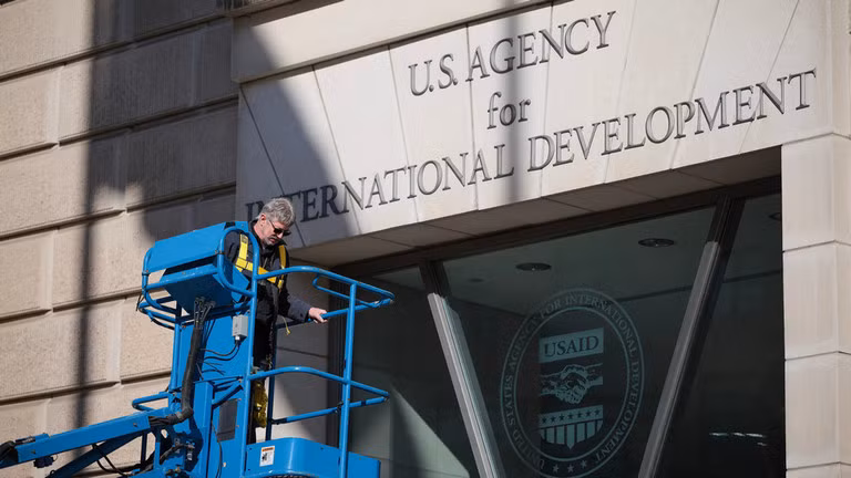 Một công nhân tháo biển hiệu USAID vào ngày 7/2 tại Washington, DC. Ảnh: Getty.