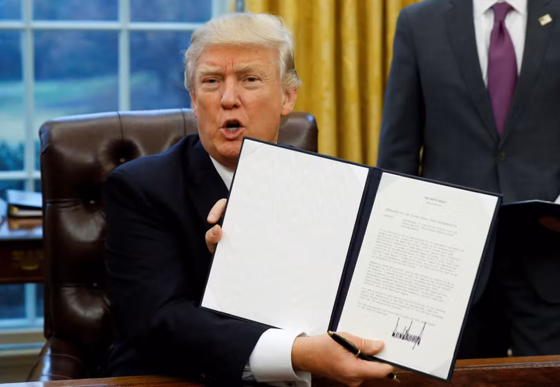 Ông Trump giơ cao sắc lệnh kèm chữ ký của mình về việc rút Mỹ khỏi TPP hồi tháng 1/2017 (Ảnh: Nikkei)