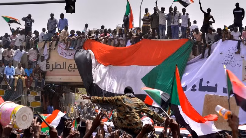 Một sĩ quan quân đội đứng giữa đám đông người biểu tình ở Thủ đô Khartoum, Sudan (Ảnh: Reuters)