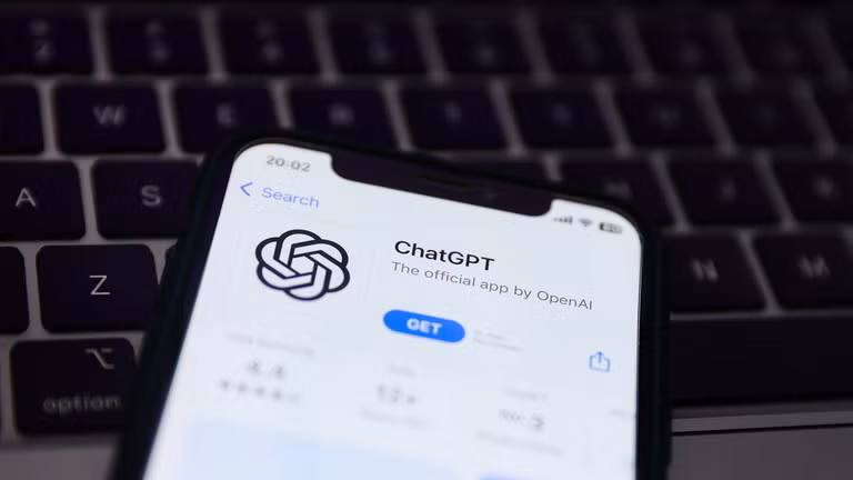 Bàn phím máy tính xách tay và trang web ChatGPT hiển thị trên màn hình điện thoại. Ảnh: Getty.