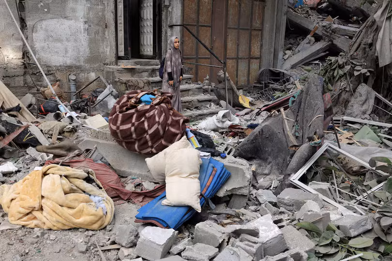 Một phụ nữ Palestine đang kiểm tra hiện trường vụ không kích của Israel vào một ngôi nhà ở thành phố Gaza hôm 7/8. Ảnh: Reuters.