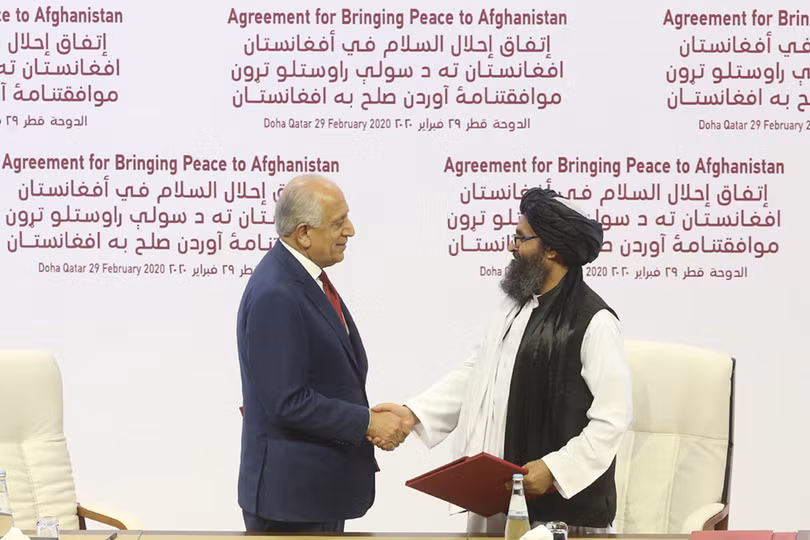Trưởng đoàn đàm phán của Mỹ, ông Zalmay Khalilzad (trái) và trưởng đoàn đàm phán của Taliban Mullah Abdul Ghani Baradar trong lễ ký thỏa thuận ở Doha (Ảnh: Politico)