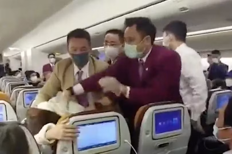 Một bức ảnh chụp cho thấy nữ hành khách Trung Quốc bị khống chế sau khi ho vào nữ tiếp viên của hãng Thai Airways (Ảnh: Handout)