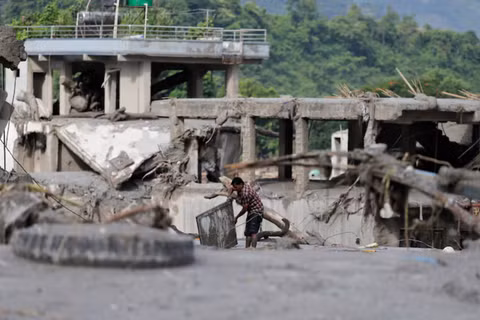 Một người đàn ông đang vớt vát đồ đạc của mình khỏi lớp bùn sau trận lũ lụt tàn khốc, tại Trishuli thuộc huyện Nuwakot, Nepal, ngày 27/8. Ảnh: Reuters.