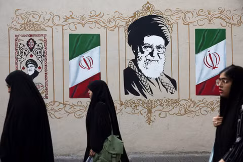 Người dân đi bộ ngang qua bức tranh tường mô tả cố lãnh đạo tối cao của Iran, Ayatollah Ali Khamenei, trên một con phố ở Tehran, Iran, ngày 13/8. Ảnh: Reuters.