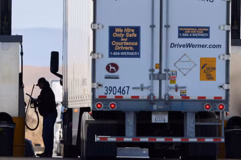 Một tài xế vận hành máy bơm nhiên liệu diesel tại trạm dừng xe tải ở Dunnigan, California, Mỹ, ngày 28/9. Ảnh: Reuters.