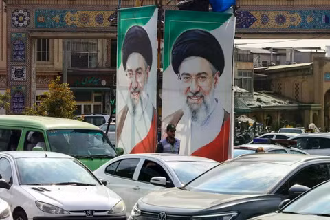 Một sĩ quan cảnh sát điều tiết giao thông khi đứng dưới chân dung của Lãnh đạo tối cao Iran Mojtaba Khamenei ở Tehran vào ngày 21/10. Ảnh: AFP.