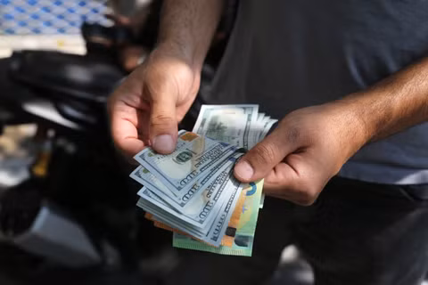 Iran vẫn phụ thuộc vào đồng USD để thực hiện một số loại giao dịch quốc tế. Ảnh: Getty.
