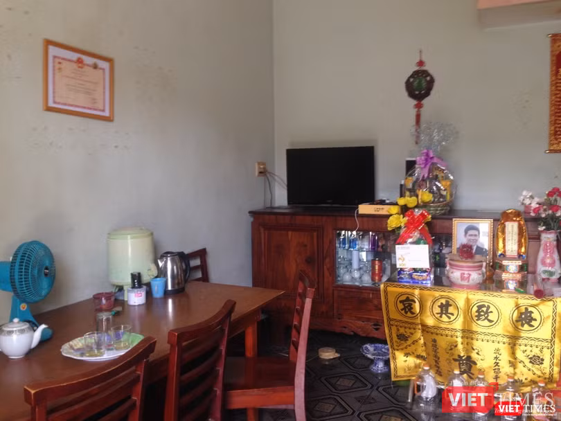 Bà trịnh trọng đặt bằng khen và kỷ niệm chương của Bộ Y tế tặng cạnh bên bàn thờ chồng. Ảnh: Nguyễn Trăm Bà trịnh trọng đặt bằng khen và kỷ niệm chương của Bộ Y tế tặng cạnh bên bàn thờ chồng. Ảnh: Nguyễn Trăm