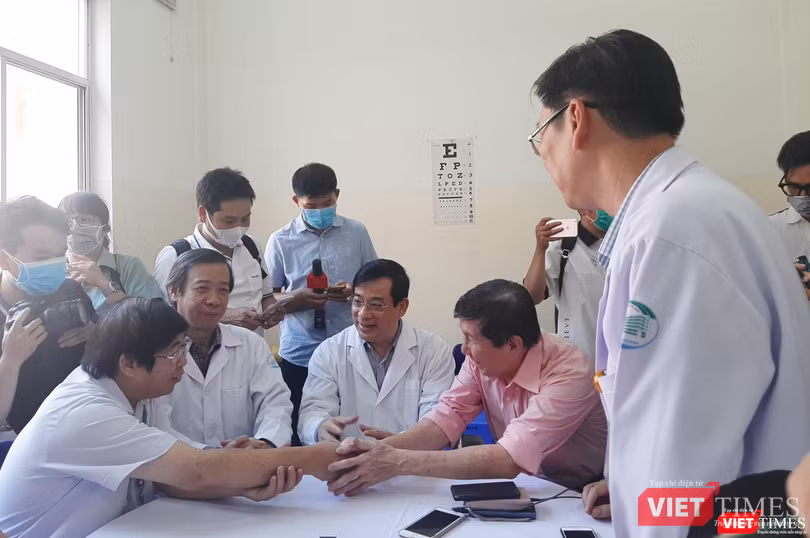 Bệnh nhân và bác sĩ ngồi sát cạnh nhau, thoải mái chia sẻ niềm vui và không ai mang khẩu trang y tế. Ảnh: Nguyễn Trăm