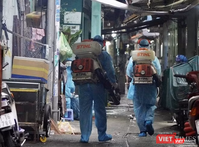 Lực lượng chức năng phun khử khuẩn khu vực BN sinh sống - Ảnh: HCDC