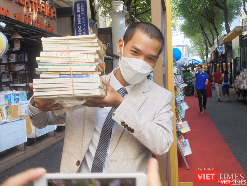 Chú rể Nguyễn Tú Anh hào hứng nhận từng chồng sách tặng. Ảnh: Hoà Bình