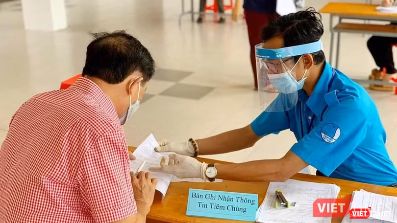 Tình nguyện viên lấy thông tin của người được tiêm chủng COVID-19. Ảnh: HCDC