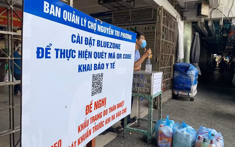 BQL chợ Nguyễn Tri Phương yêu cầu người dân cài đặt Bluzone và khai báo y tế trước khi vào chợ - Ảnh: LĐ