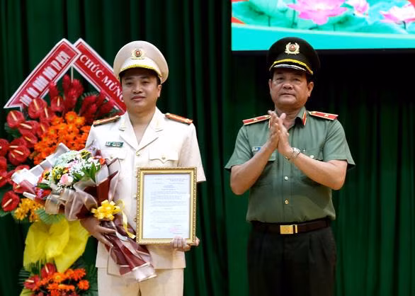 Thiếu tướng Lê Hồng Nam (phải) - Giám đốc Công an TP.HCM thừa ủy quyền của Bộ trưởng Bộ Công an trao quyết định điều động đại tá Mai Hoàng giữ chức vụ Phó Giám đốc Công an TP.HCM. Ảnh: Tuổi trẻ