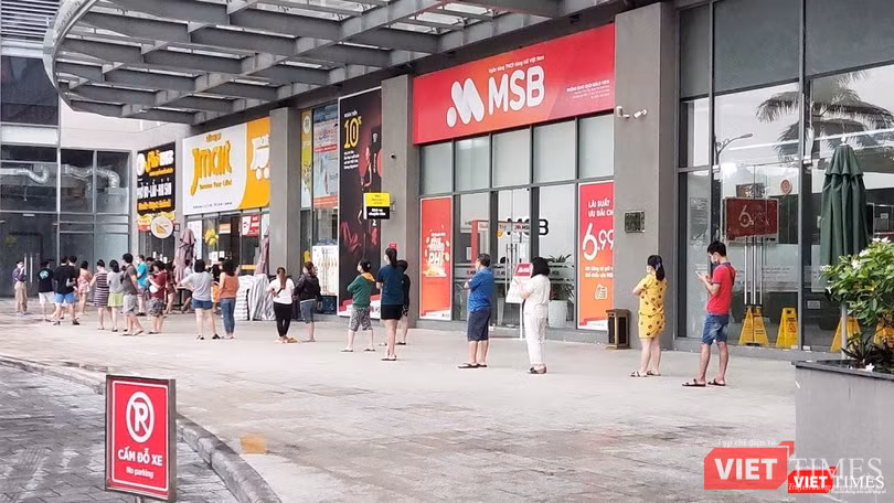Hàng trăm người dân xếp hàng cả tiếng trước cửa một siêu thị tại quận 4. Siêu thị này cung cấp thực phẩm cho khoảng 2.000 căn hộ - Ảnh: Hoà Bình