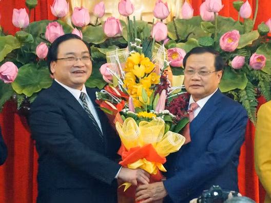 Ông Phạm Quang Nghị (phải) tặng hoa chúc mừng tân Bí thư Hà Nội Hoàng Trung Hải trong ngày nhậm chức