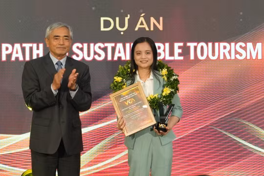 Chủ tịch VDCA Nguyễn Minh Hồng trao giải Nội dung đào tạo cộng đồng ấn tượng, ghi nhận Dự án Path to Sustainable Tourism của tác giả Trịnh Thị Yến Nhi. Ảnh: BTC.