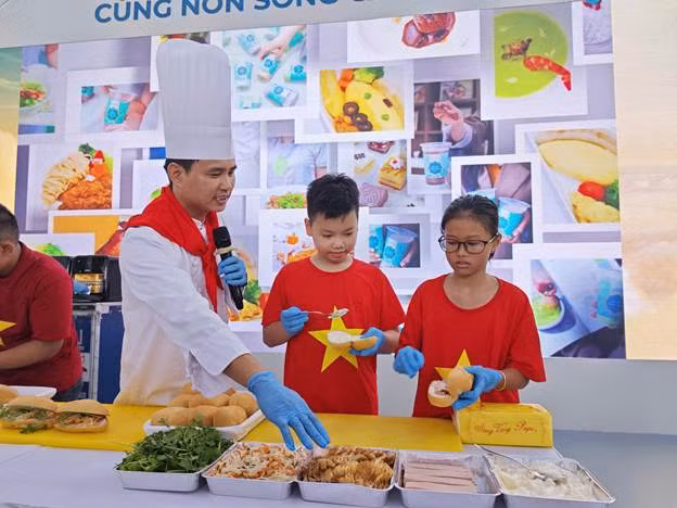 Em nhỏ say sưa tạo hình chiếc bánh mỳ đầu tiên của mình. (Ảnh: VNA).
