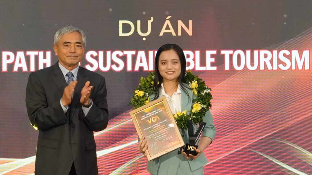 Chủ tịch VDCA Nguyễn Minh Hồng trao giải Nội dung đào tạo cộng đồng ấn tượng, ghi nhận Dự án Path to Sustainable Tourism của tác giả Trịnh Thị Yến Nhi. Ảnh: BTC.