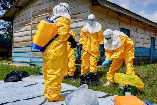 Các nhân viên Chữ thập đỏ khử khuẩn sau khi xử lý thi thể một người tử vong do Ebola tại Congo. Ảnh: Reuters