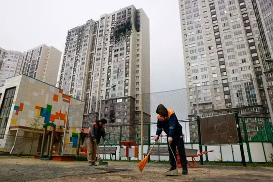 Ngày 20/9, các công nhân ở Kotelniki thuộc vùng Moscow dọn dẹp đống đổ nát gần một tòa nhà chung cư cao tầng bị hư hại do vụ tấn công bằng máy bay không người lái của Ukraine. Ảnh: Reuters.