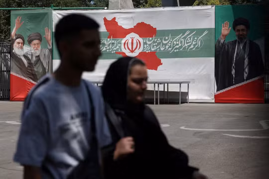 Người dân đi ngang qua một tấm biểu ngữ trên một con phố ở Tehran, Iran, ngày 9/6. Ảnh: Reuters.