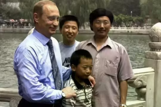 Tổng thống Nga Vladimir Putin chụp ảnh cùng Bành Bái, khi đó 12 tuổi, và các thành viên trong gia đình của cậu, tại công viên Bắc Hải, Bắc Kinh vào ngày 17/7/2000. Ảnh: Baidu.