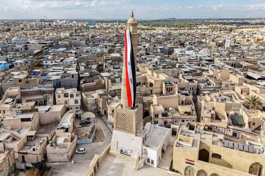 Quốc kỳ cỡ lớn của Iraq được treo trên Thánh đường Hồi giáo al-Nuri ở khu phố cổ Mosul hôm 29/9. Với việc kết thúc Chiến dịch Inherent Resolve, những binh sĩ cuối cùng trong số 2.500 binh sĩ Mỹ đóng quân tại Iraq đã rời đi. Ảnh: AFP.