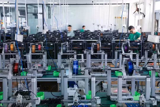 Các công nhân kiểm tra máy móc tại một nhà máy in 3D ở Thâm Quyến. Ảnh: Xinhua.