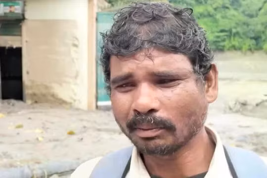 Ông Talka Sada, với chiếc ba lô trên vai, đang đi bộ xuyên qua các khu vực bị lũ lụt tàn phá ở Nepal để tìm kiếm con trai mất tích của mình. Ảnh: AJ.