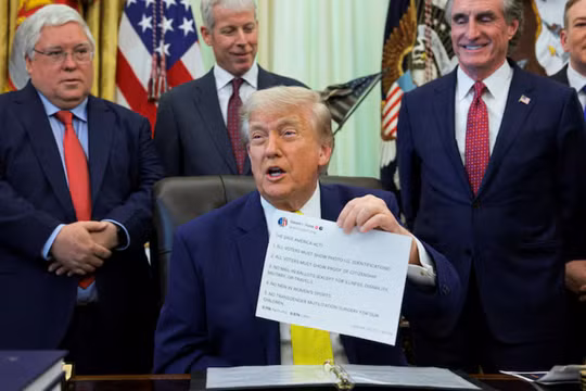 Tổng thống Mỹ Donald Trump giơ bản in bài đăng trên Truth Social của mình khi đang phát biểu trước các phóng viên tại Phòng Bầu dục ở Nhà Trắng tại Washington, D.C., Mỹ, ngày 4/6. Ảnh: Reuters.