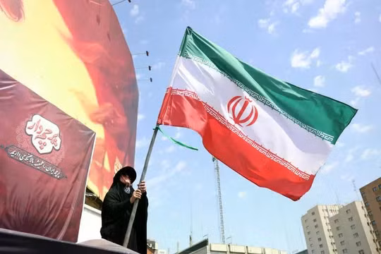 Một phụ nữ Iran giương cao quốc kỳ Iran tại quảng trường Valiasr ở Tehran, Iran, ngày 17/8. Ảnh: EPA.