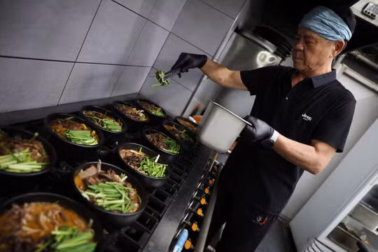 Ông Lee Kang-chun, chủ một nhà hàng bán món hầm thịt chó và thịt dê đen, đang nấu các món ăn tại nhà hàng của mình ở Seongnam, Hàn Quốc, ngày 14/8. Ảnh: Reuters.