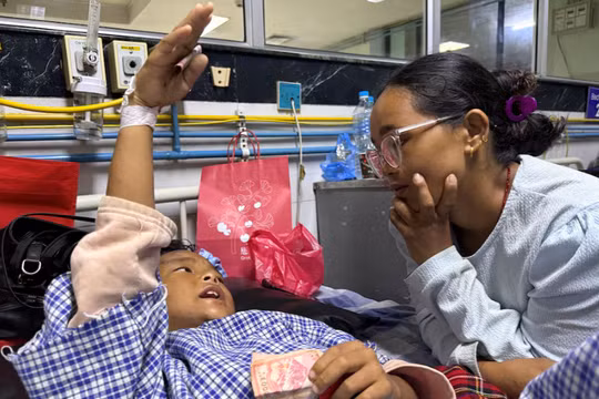 Zoyal Ghale, 8 tuổi, được trực thăng đưa đi cấp cứu từ Rasuwa sau khi bị thương trong trận lũ quét và sạt lở đất kinh hoàng, đang trò chuyện với mẹ mình, Matti Maya Tamang, 28 tuổi, hai ngày sau khi hai mẹ con bị chia cắt do lũ lụt, bên trong một bệnh viện ở Kathmandu, Nepal, ngày 28/8. Ảnh: Reuters.